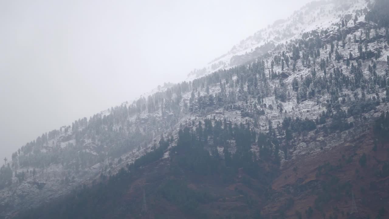 在印度喜马偕尔邦的马纳里，山顶在冬季被雪覆盖的景象。山顶在冬季被雪和雾覆盖。视频素材