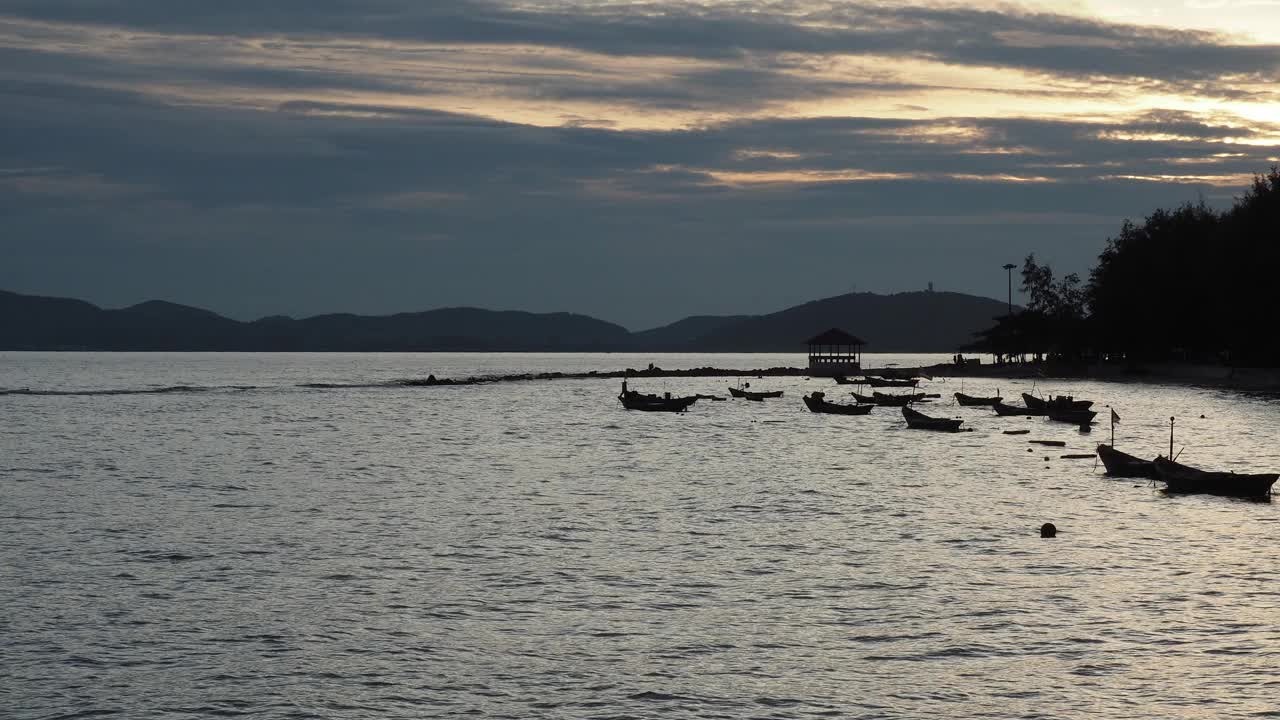 日落时小船的轮廓。蓝色的天空变成了金色的夕阳。泰国湾。视频下载