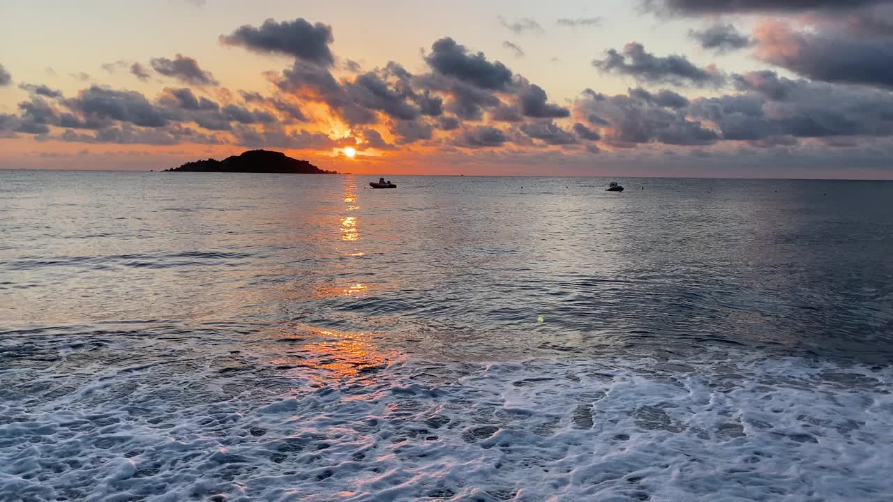 橙色黎明的大海，地平线上有一个小岛视频素材