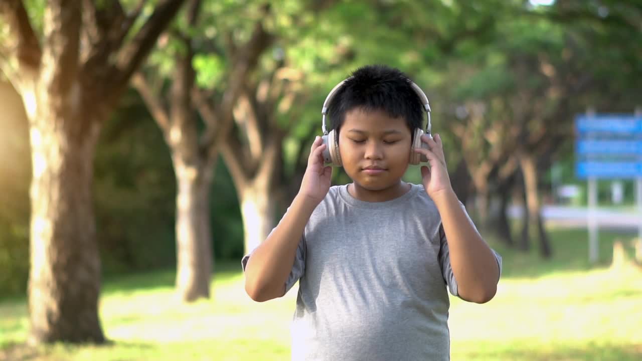 戴着耳机微笑快乐的小男孩。人、生活方式和快乐理念。视频素材