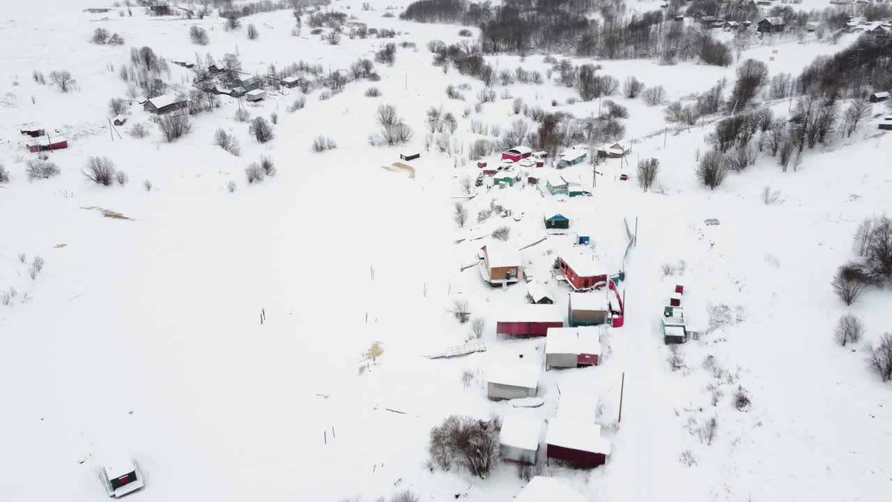 从无人机鸟瞰的一个小村庄，冬天的风景，霜天，一切都被雪覆盖视频下载