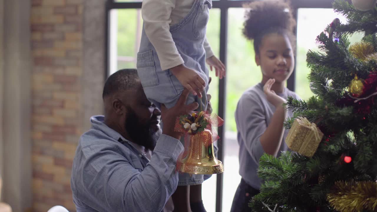 非裔美国家庭在公寓里一起装饰圣诞树视频素材