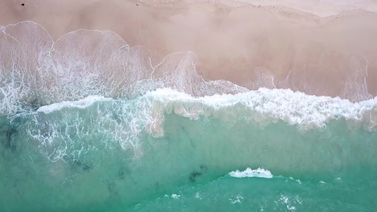 鸟瞰图热带海滩和波浪与白色的沙滩和蓝色的大海视频素材