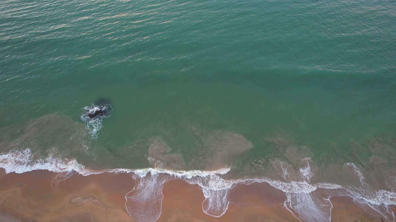 无人机拍摄的海浪拍打在海滩上视频素材