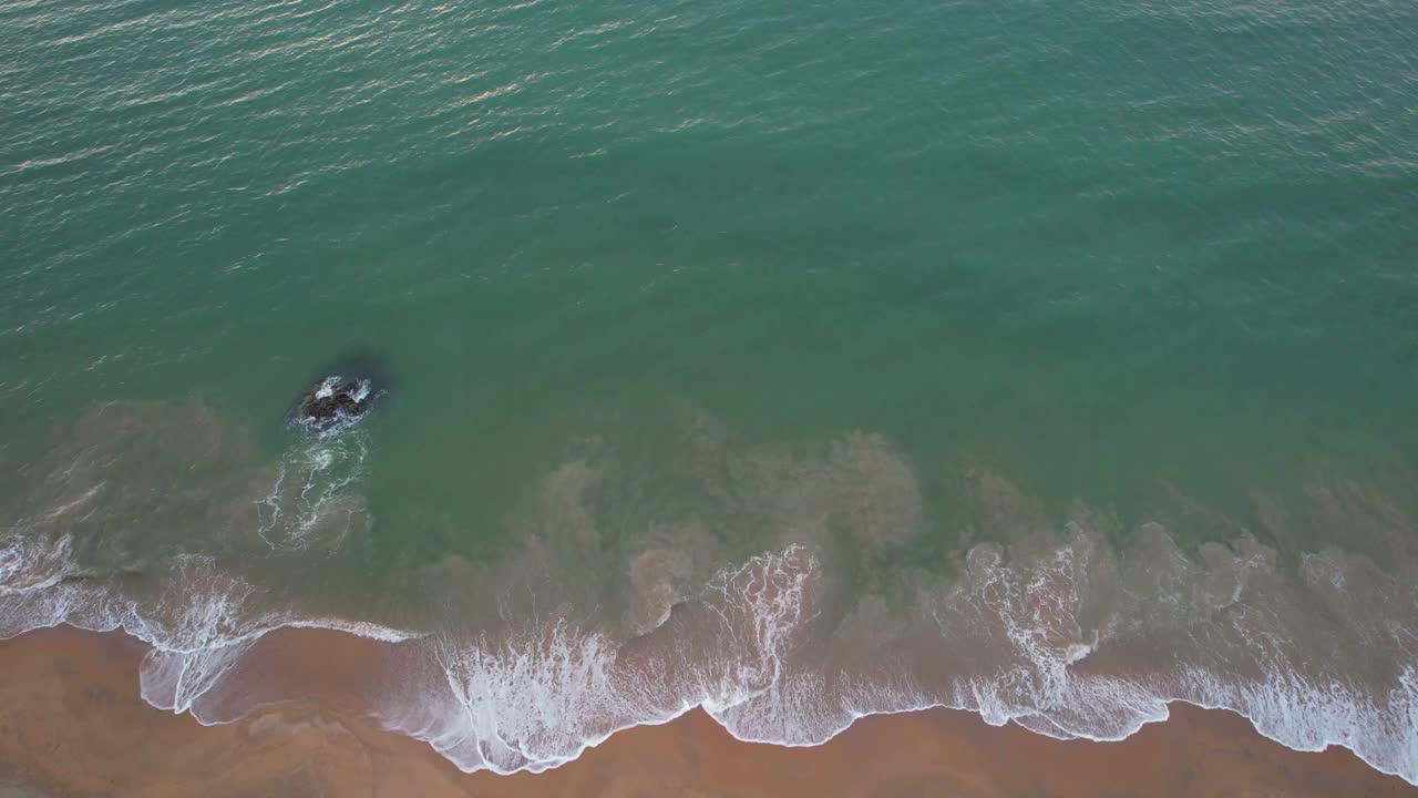 无人机拍摄的海浪拍打在海滩上视频素材