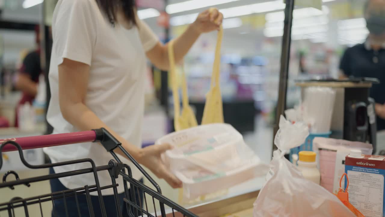 亚洲年轻女子在超市使用可重复使用的袋子购物视频素材