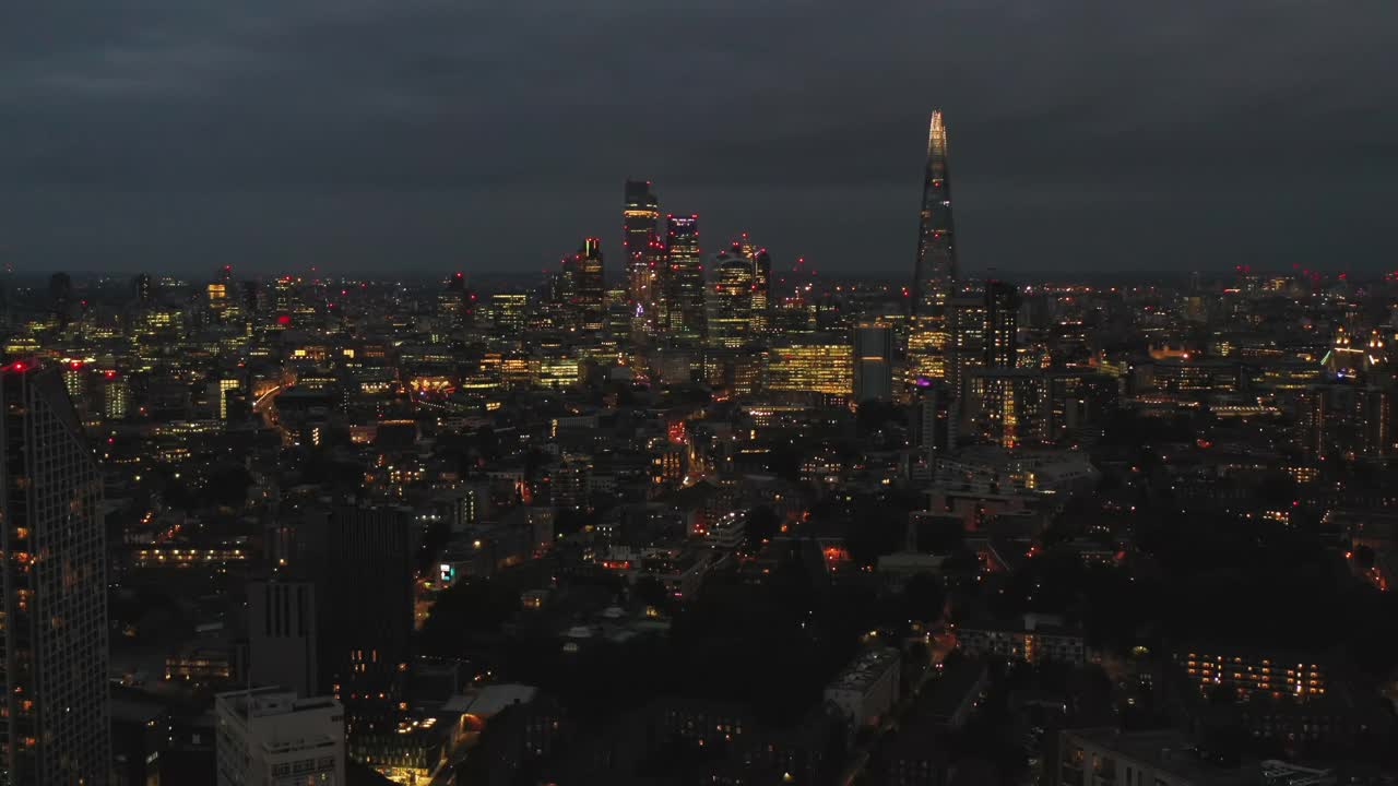 向后飞，俯瞰夜景。城市商业中心和碎片大厦的摩天大楼群。英国伦敦视频素材