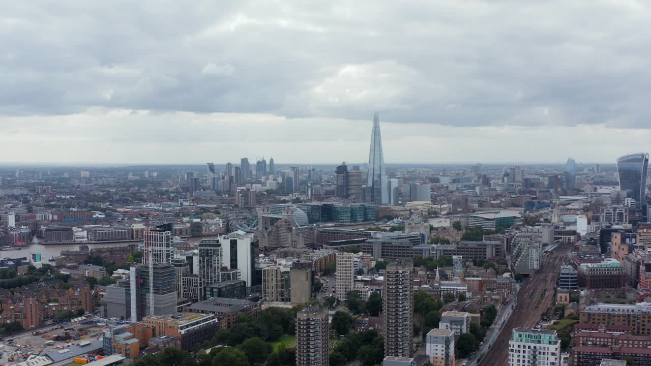 向后飞到城镇上空。城市街区的空中全景和远处的摩天大楼。英国伦敦视频素材