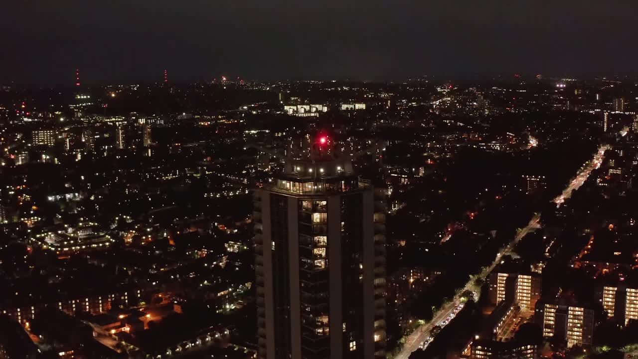 空中拍摄的夜景。向前飞，向下倾斜到高层建筑的顶部。街道的交通。英国伦敦视频素材