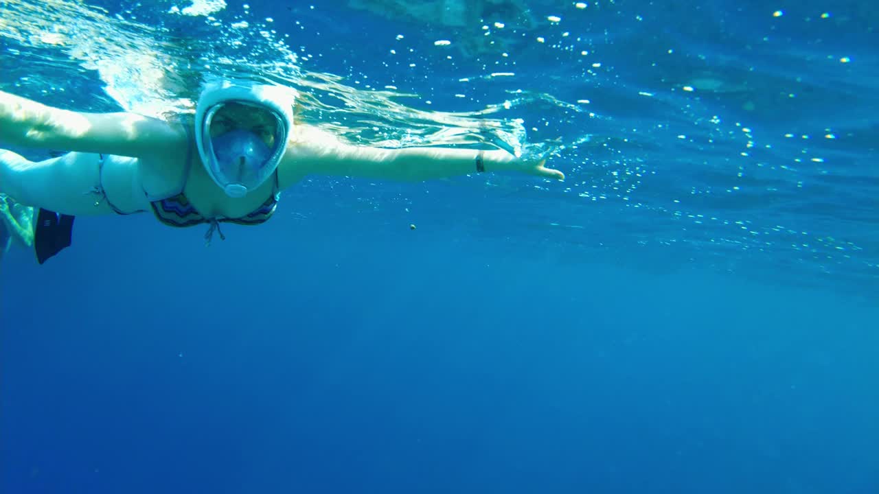 浮潜的女孩。埃及一名女孩戴着面具在浅水中游泳视频素材