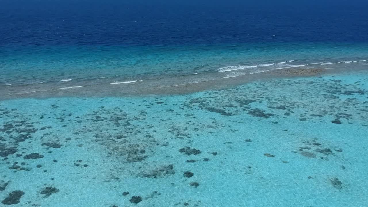 热带海滩的风景。美丽的海浪，绿色的棕榈树，蓝色的水和天空的马尔代夫视频下载