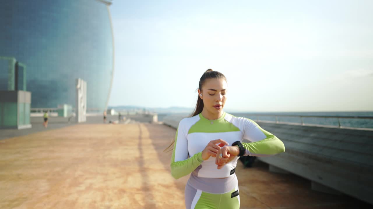 女运动员在跑步时使用智能手表视频素材