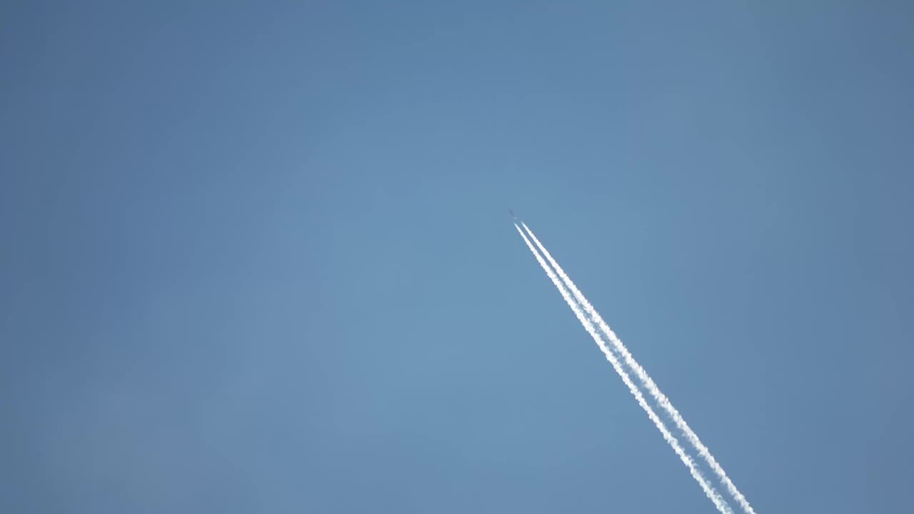 高空飞行的喷气式客机在清澈的蓝天上留下了尾迹。视频素材