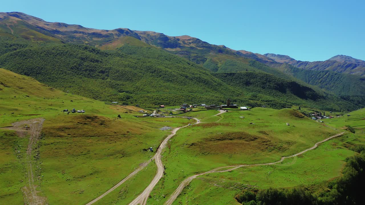 鸟瞰图的汽车沿着乡村道路从村庄到山区。视频素材