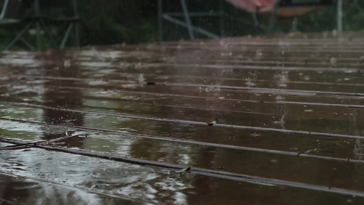 雨落在棕色的木地板上。慢镜头来看视频素材