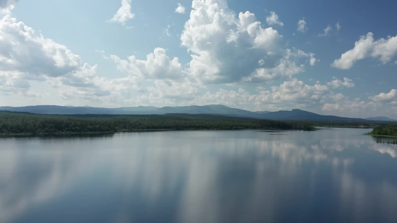 在瑞典北部的一个阳光灿烂的夏天，在水里镜像天空，无人机观看夏天的一天仍然湖视频素材