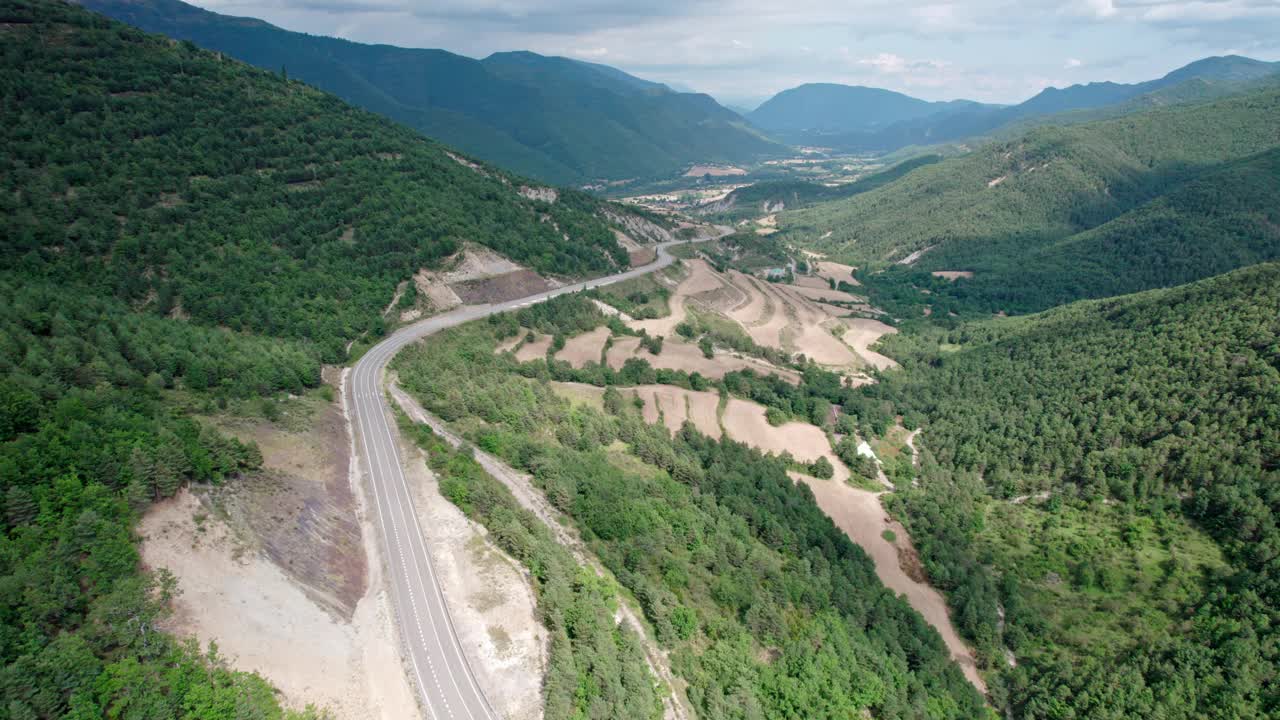 一座桥，一座山间的现代高架桥，一条三车道的柏油路。钢筋混凝土码头结构的桥梁连接两座小山，山上覆盖着森林。视频素材