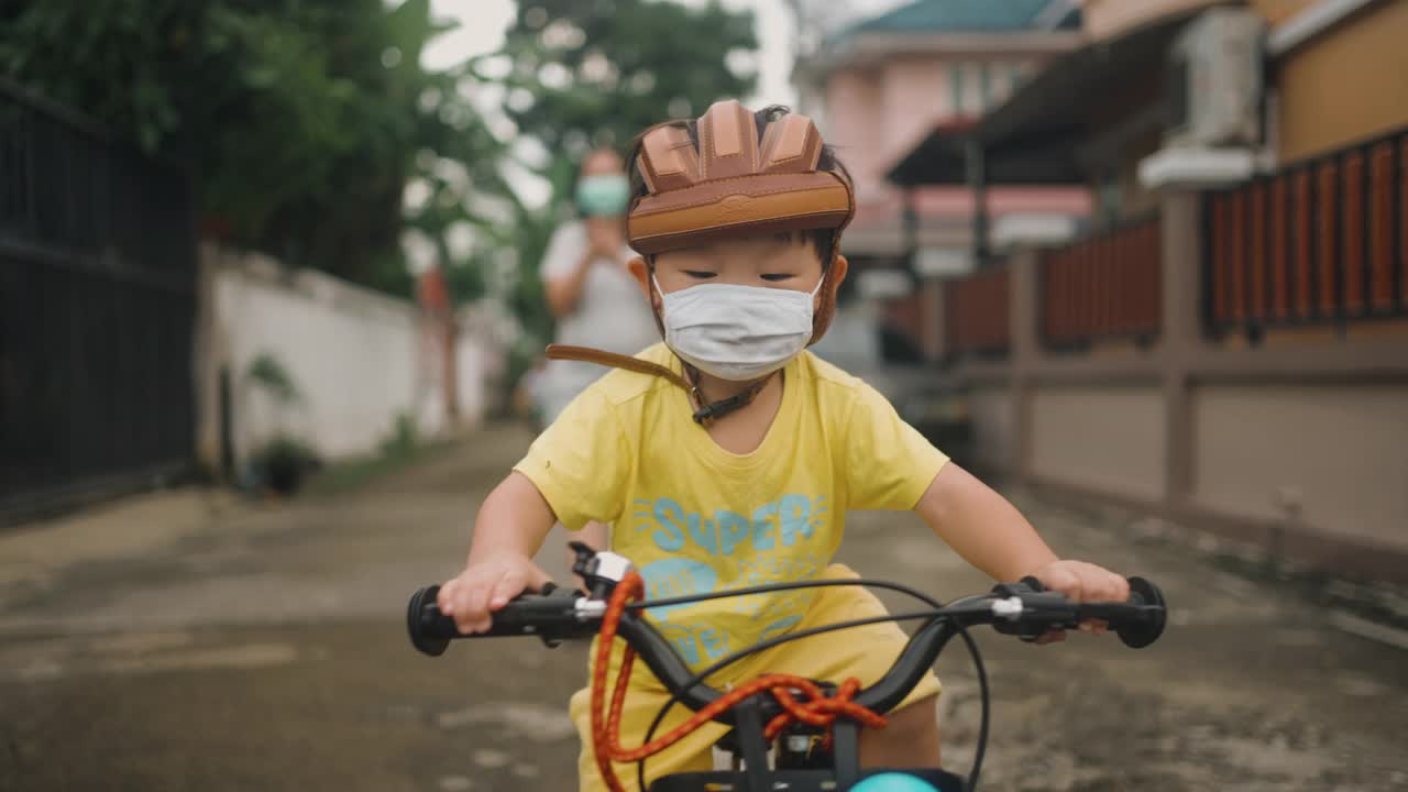 蹒跚学步的男孩正在学习骑自行车视频素材