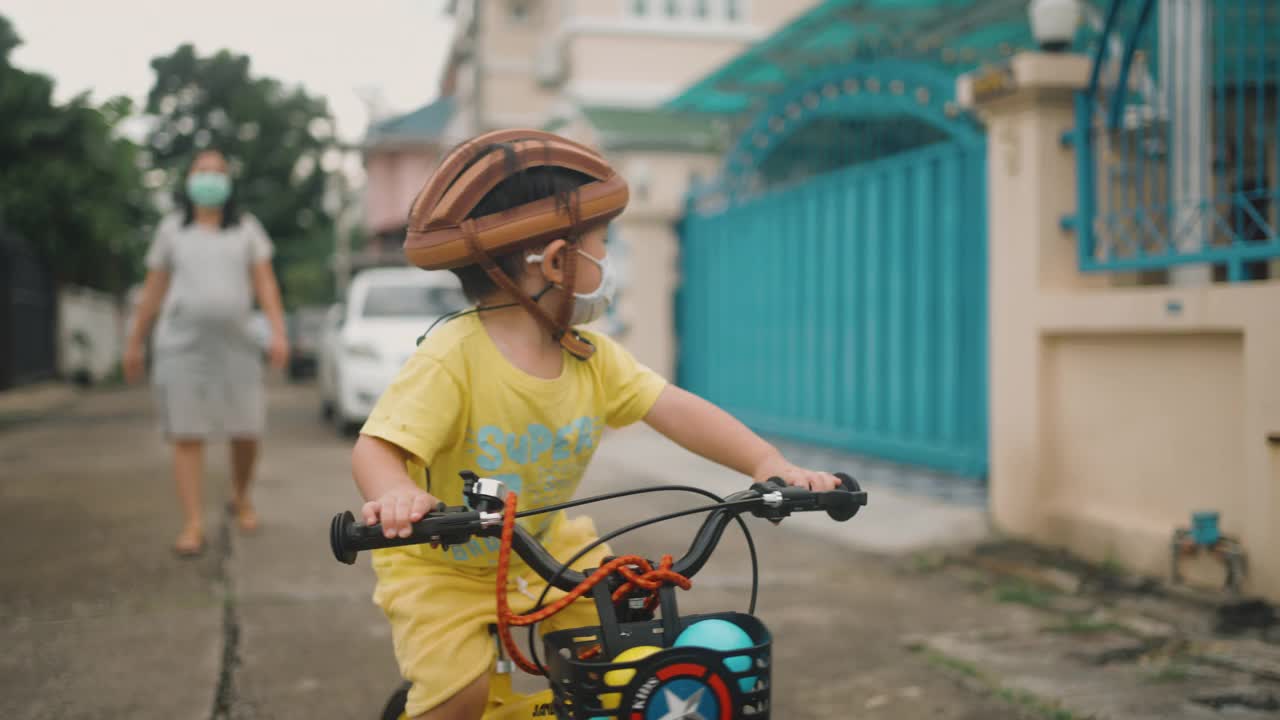 蹒跚学步的小男孩在户外骑自行车玩得很开心视频素材