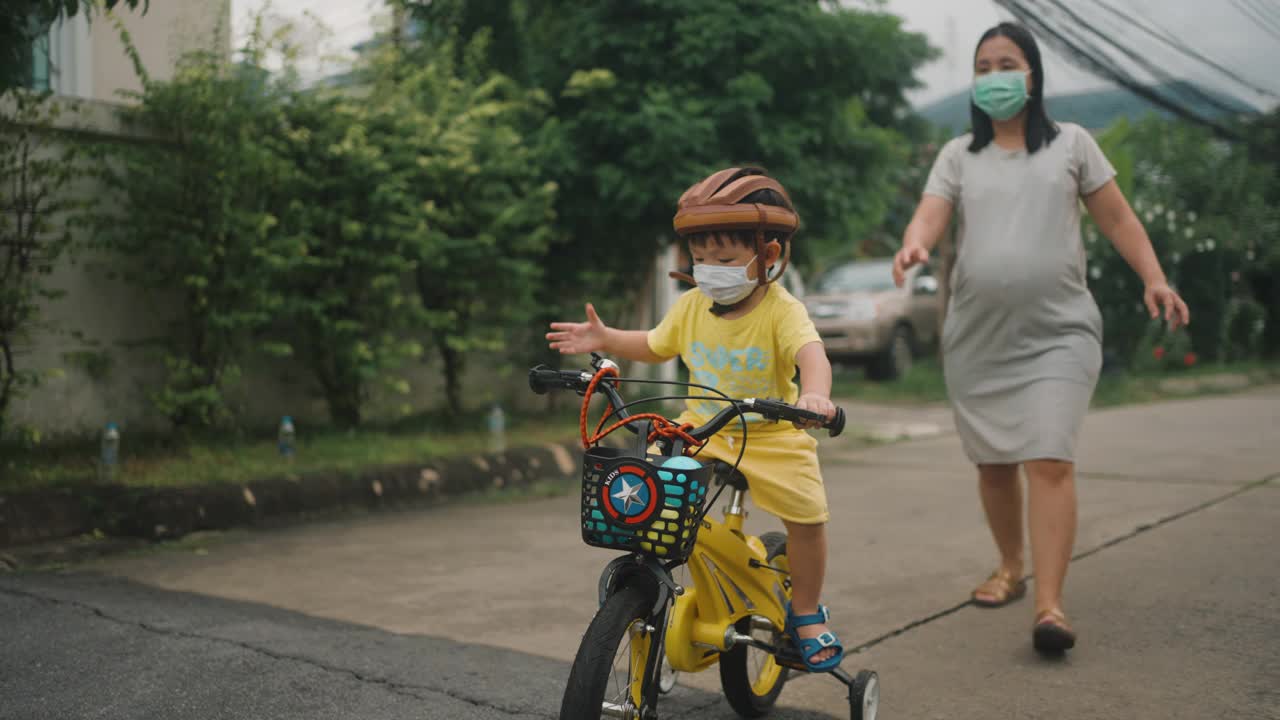 蹒跚学步的小男孩在户外骑自行车玩得很开心视频素材