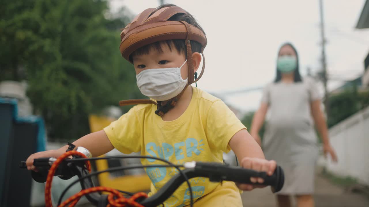 蹒跚学步的小男孩在户外骑自行车玩得很开心视频素材