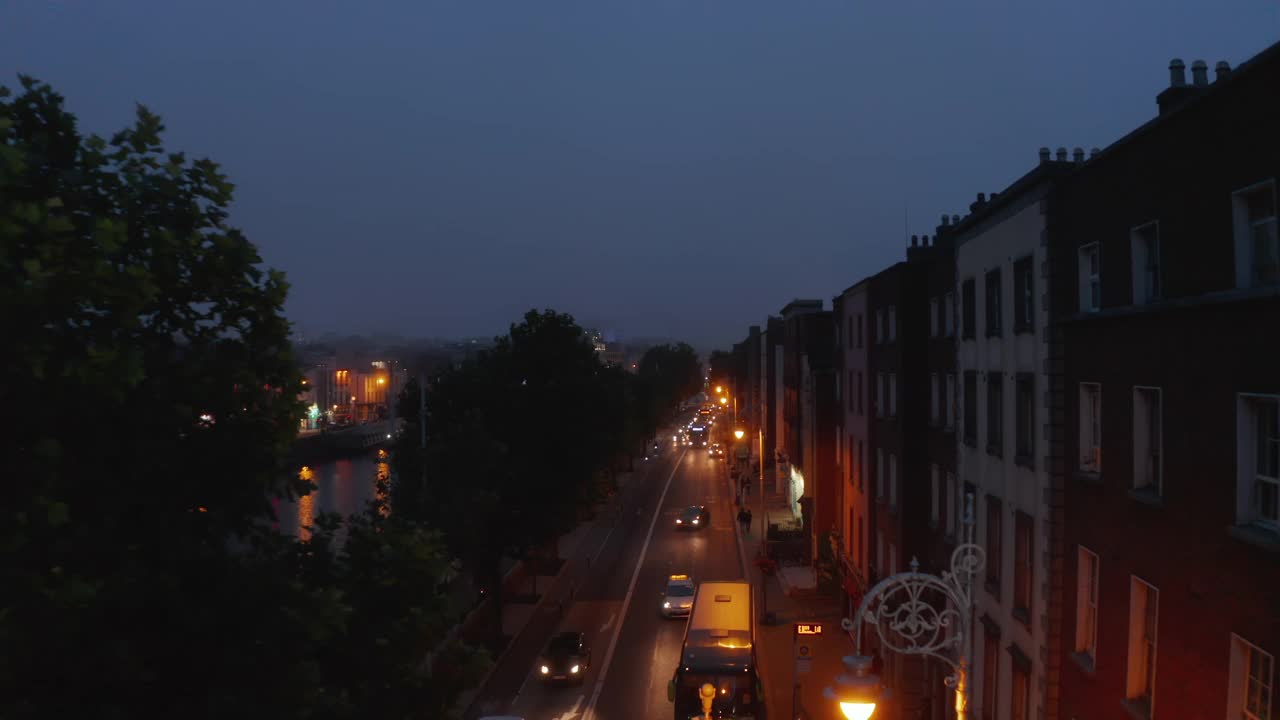 向前飞的车辆行驶在利菲河堤。灯火通明的海滨夜景。爱尔兰都柏林视频素材