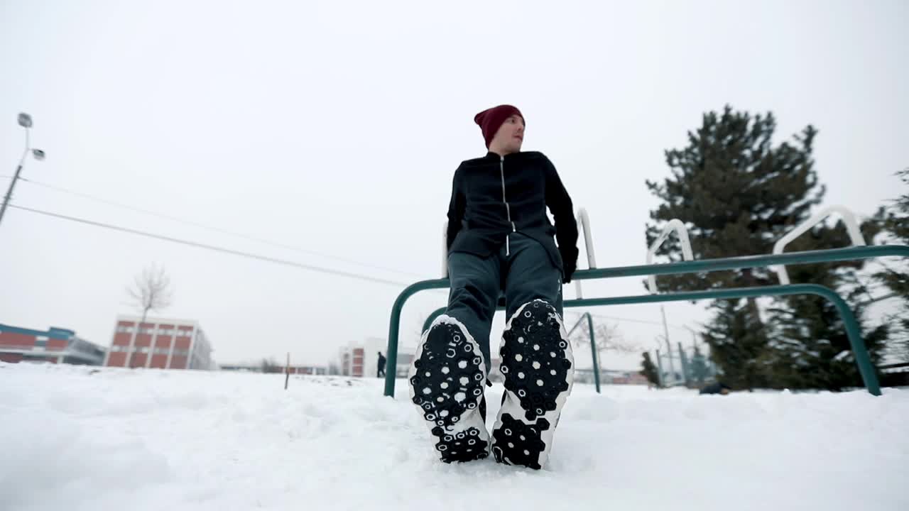 男子在雪地里做三头肌仰卧起坐视频素材