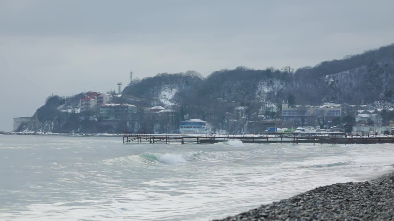 在海上风暴。从卵石滩到大海和白雪覆盖的山。缓慢的运动。冬季视频素材