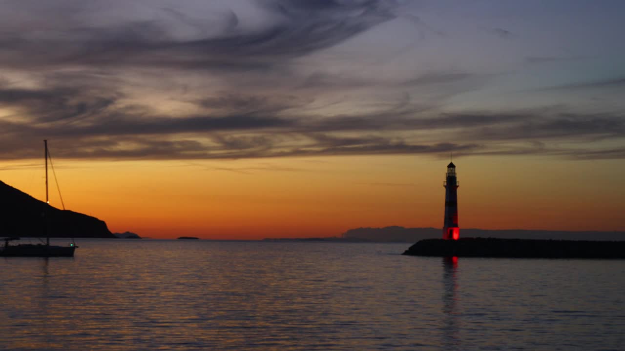 在夕阳海景。海岸上的灯塔。海边小镇Turgutreis和壮观的日落视频素材