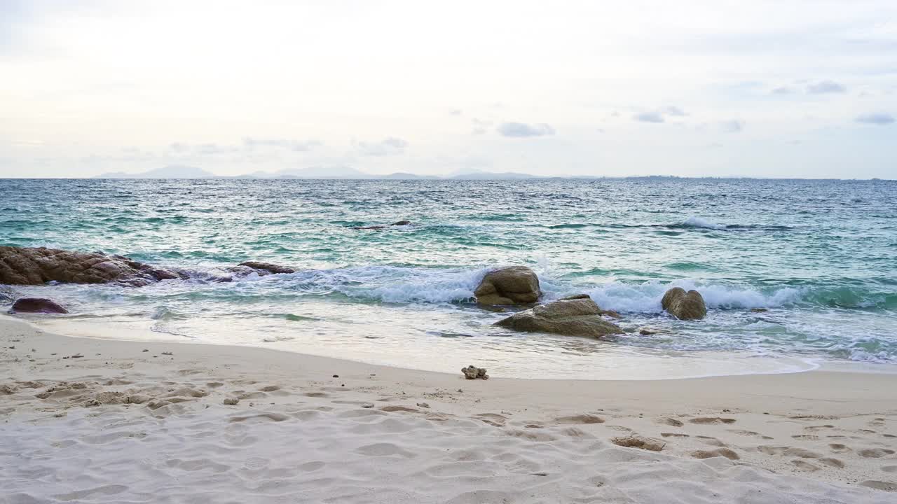 美丽的沙滩和海浪与蓝天和白云的背景。视频素材