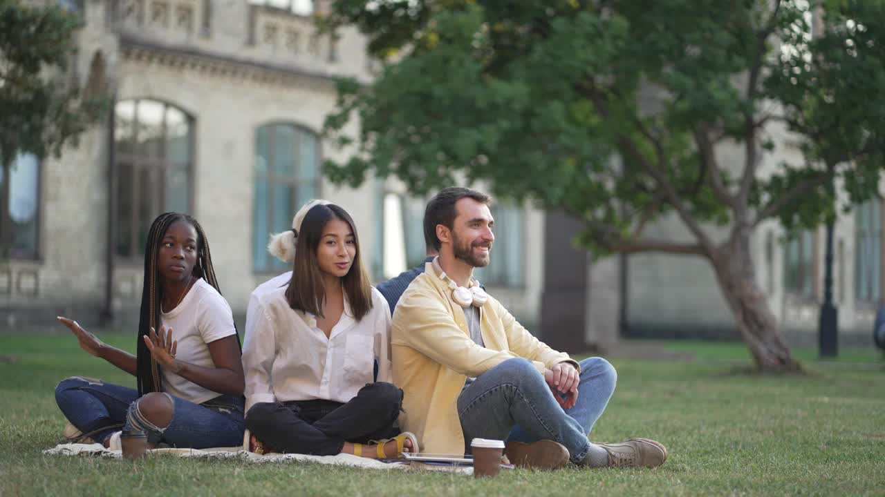 不同肤色的年轻学生在校园草坪上调情视频素材