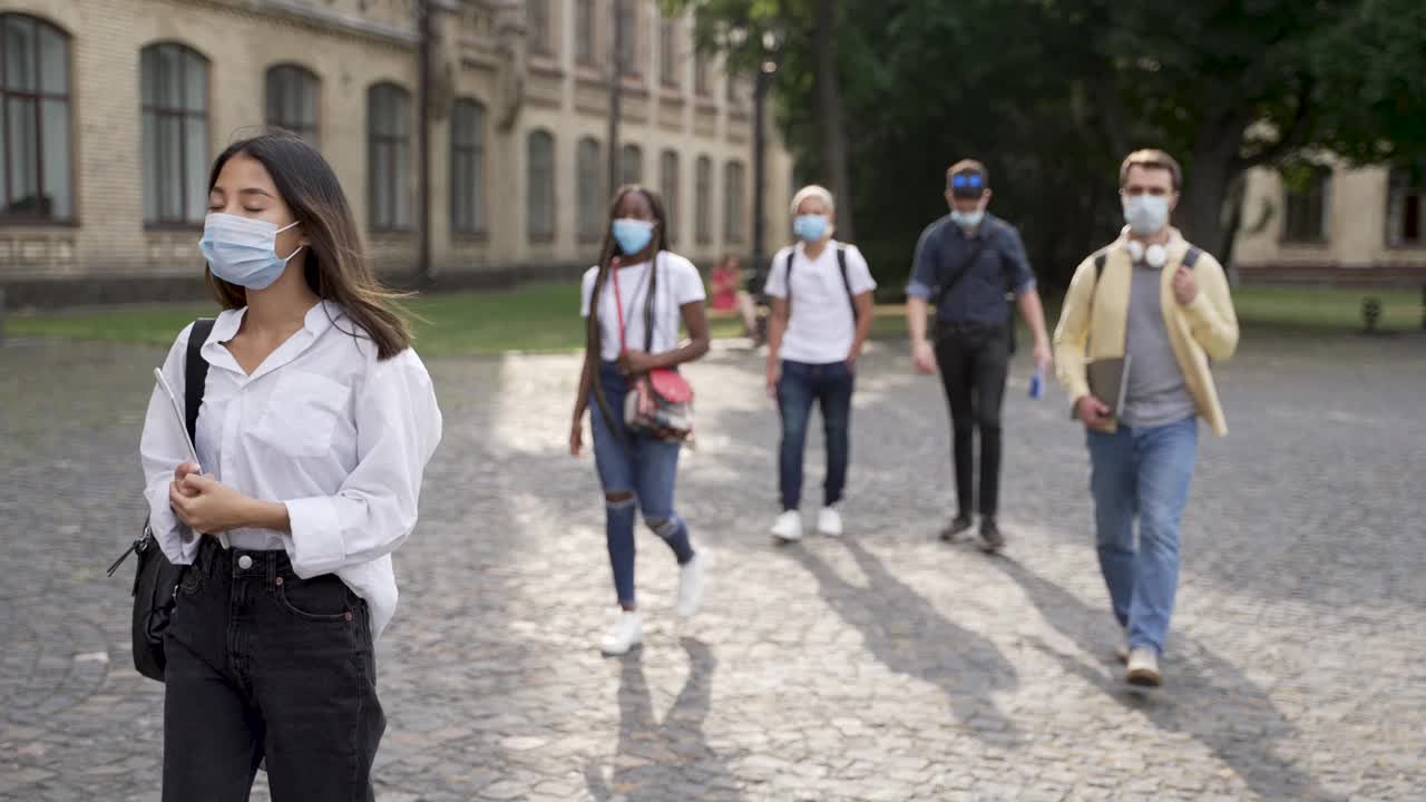 多种族学生戴着口罩去上课视频素材