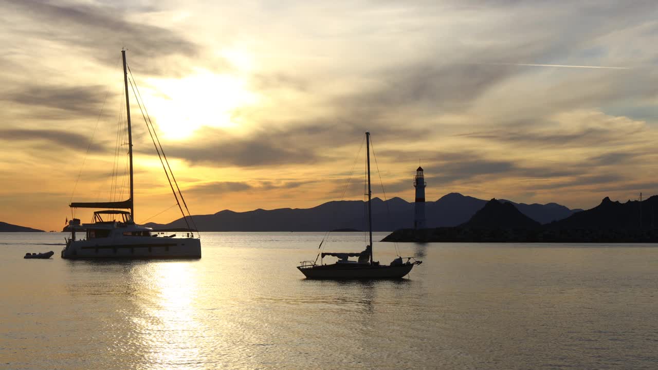 在夕阳海景。海岸上的灯塔。海边小镇Turgutreis和壮观的日落视频素材