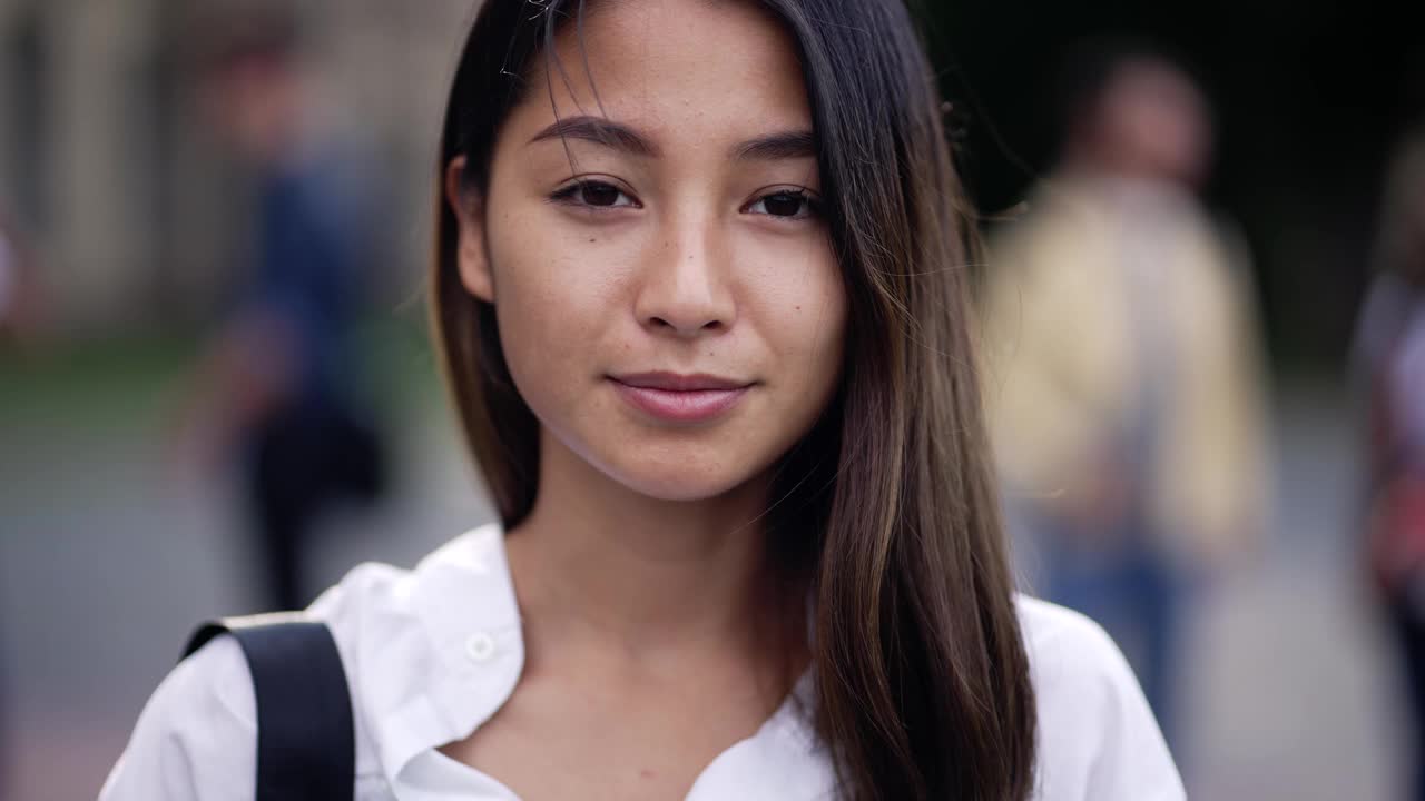 漂亮的亚洲女孩学生在户外相机摆姿势视频素材