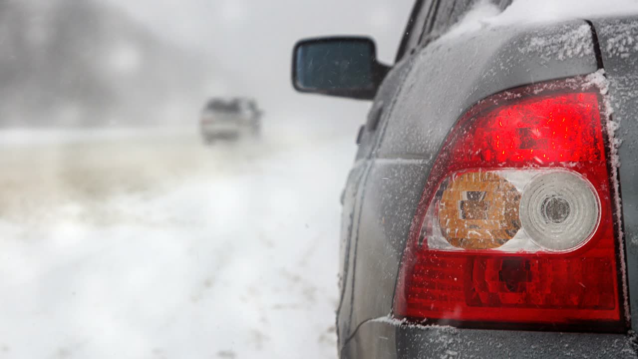 汽车在冬天的道路上，在暴风雪和恶劣的能见度，警报信号视频素材