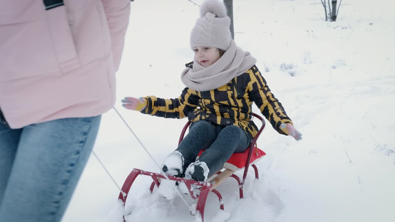 孩子们坐着雪橇走路。视频素材