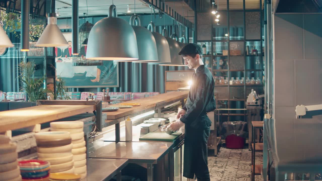 一个男人在餐馆的柜台后面做饭视频素材