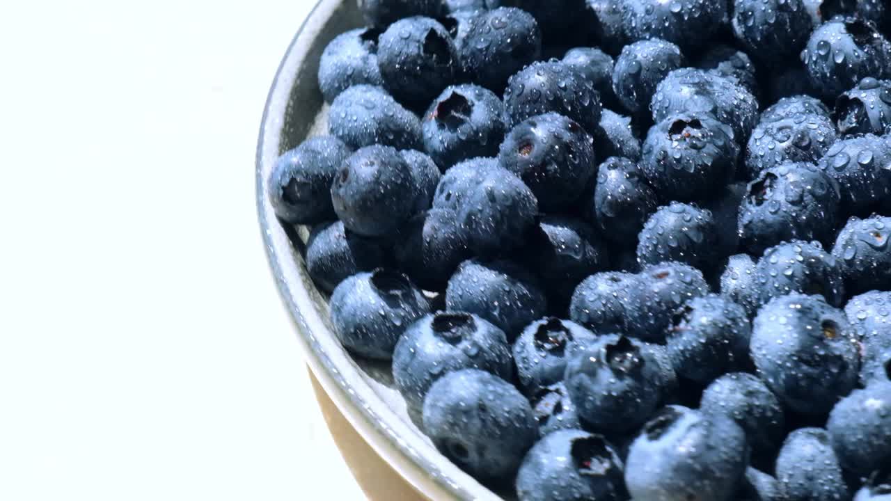 新鲜的蓝莓在盘子旋转慢动作。蓝莓抗氧化有机超级食品碗的概念健康饮食和营养。收获的概念视频素材