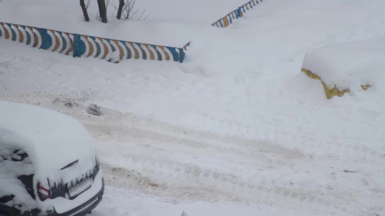 一辆垃圾车停在了冰上的雪地上。冬天的暴风雪，旋转，特写镜头。视频素材