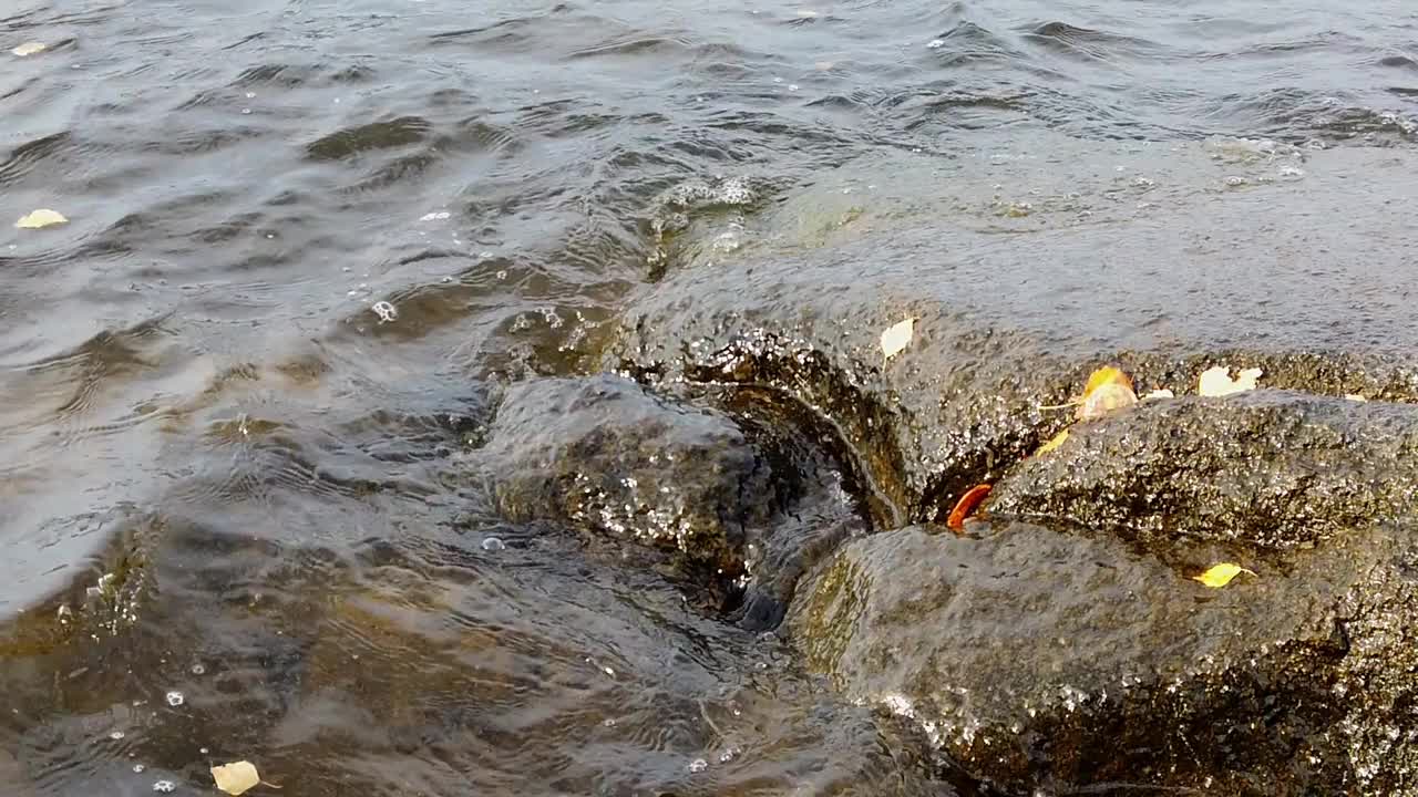 小波浪以慢动作拍打着多岩石的海岸视频素材