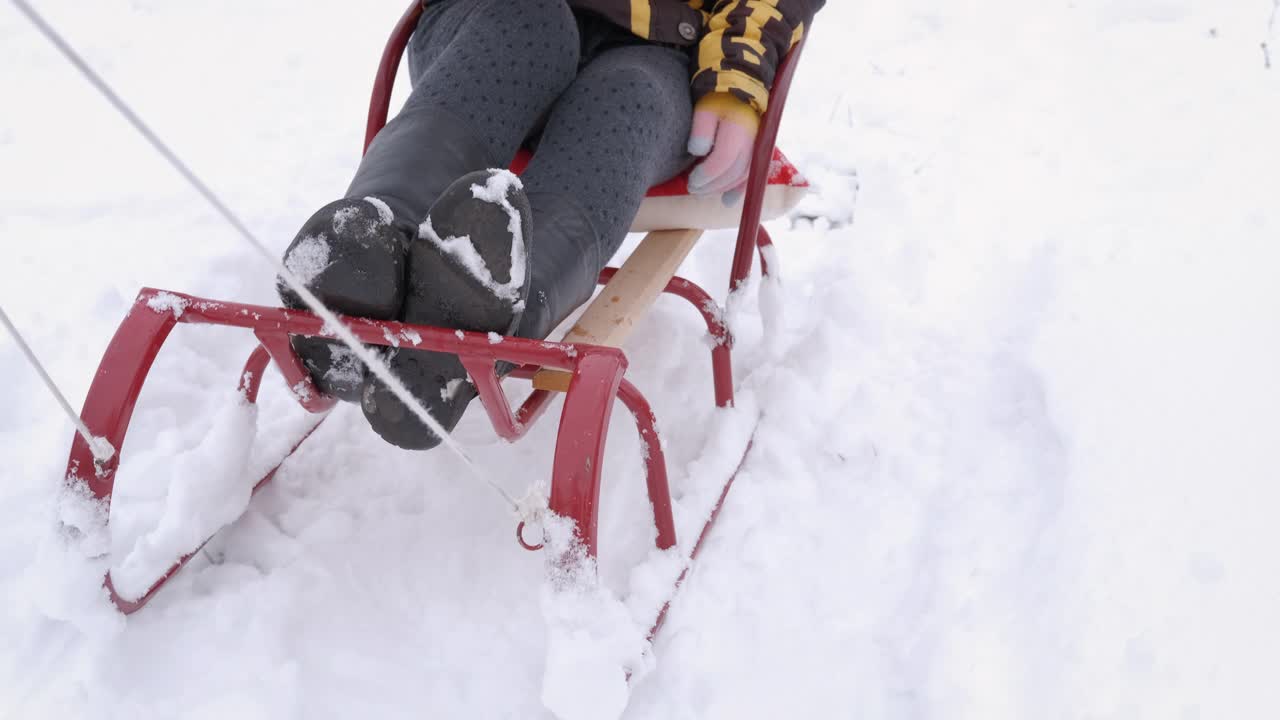 女孩坐在雪橇上。视频素材