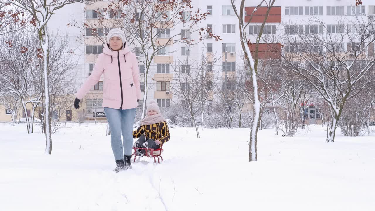 一家人坐着雪橇散步。视频素材