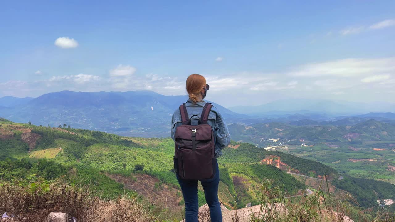 一位妇女骑着摩托车穿越群山。出去度假的概念视频素材