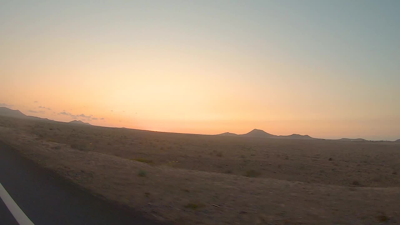 在西班牙加那利群岛的兰萨罗特，在一次公路旅行中，日落时火山景观的美丽景色。视频下载