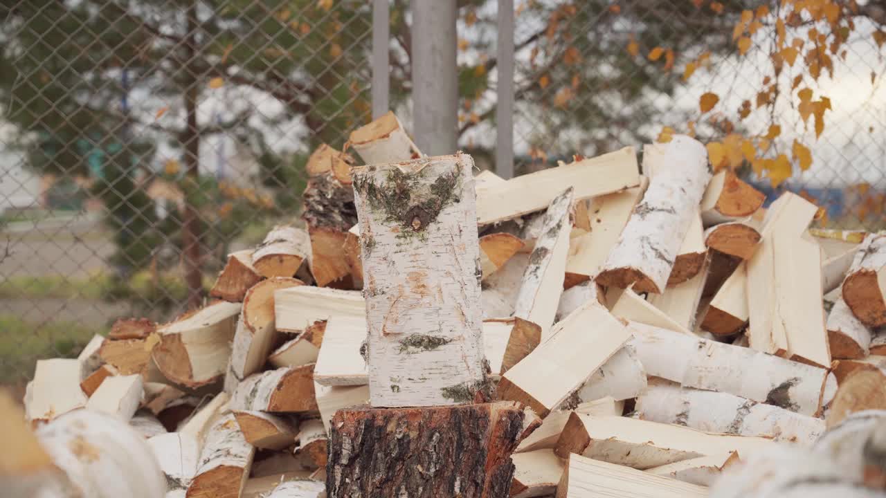 近景:斧子劈在桦木上。一个人在为壁炉砍柴。视频素材