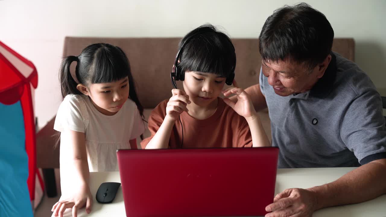 一个小男孩在家里用笔记本电脑上网学习视频素材