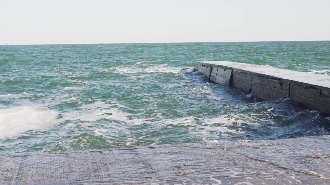 敖德萨蓝色大海的海浪。白色的波浪。石码头视频下载