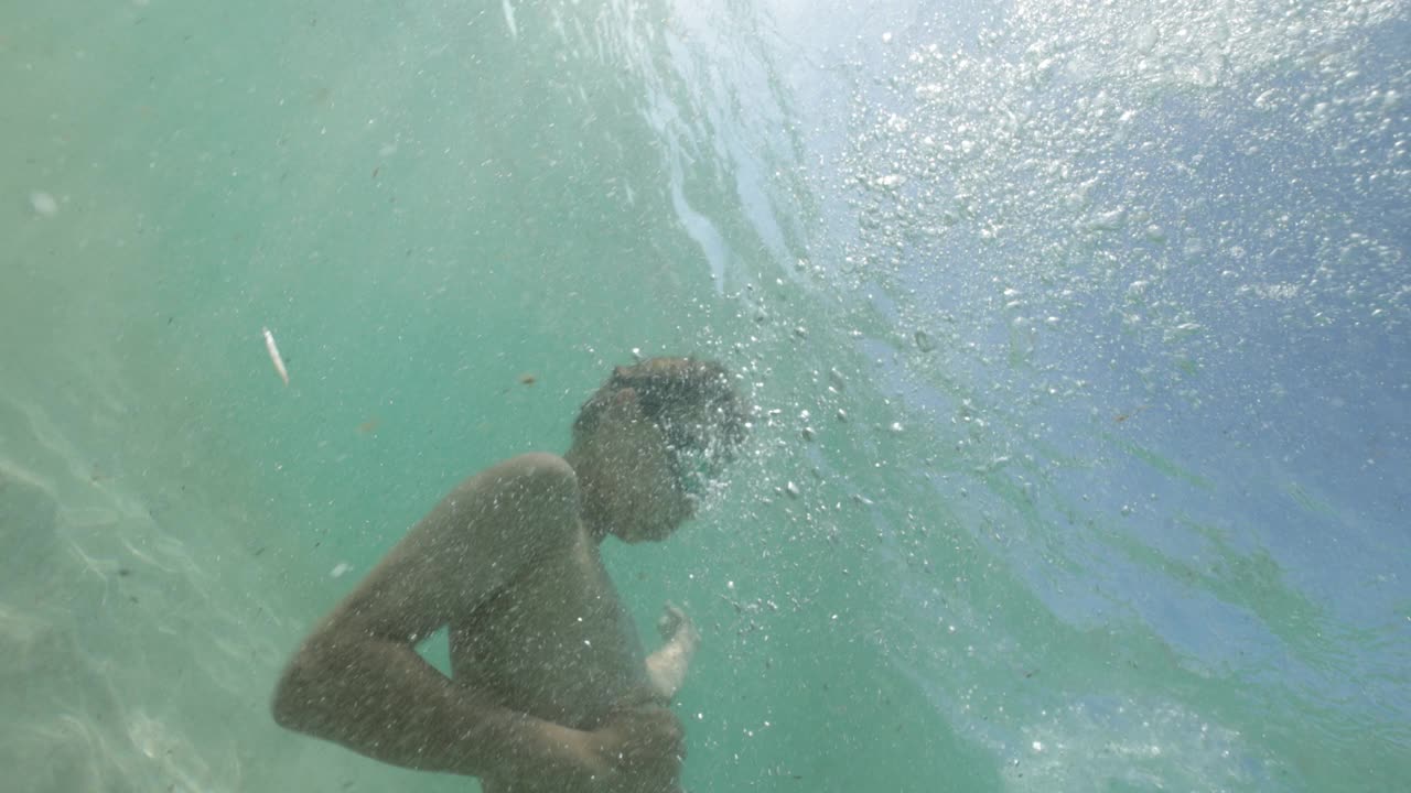 十几岁的男孩喜欢在干净的浅海里玩视频素材