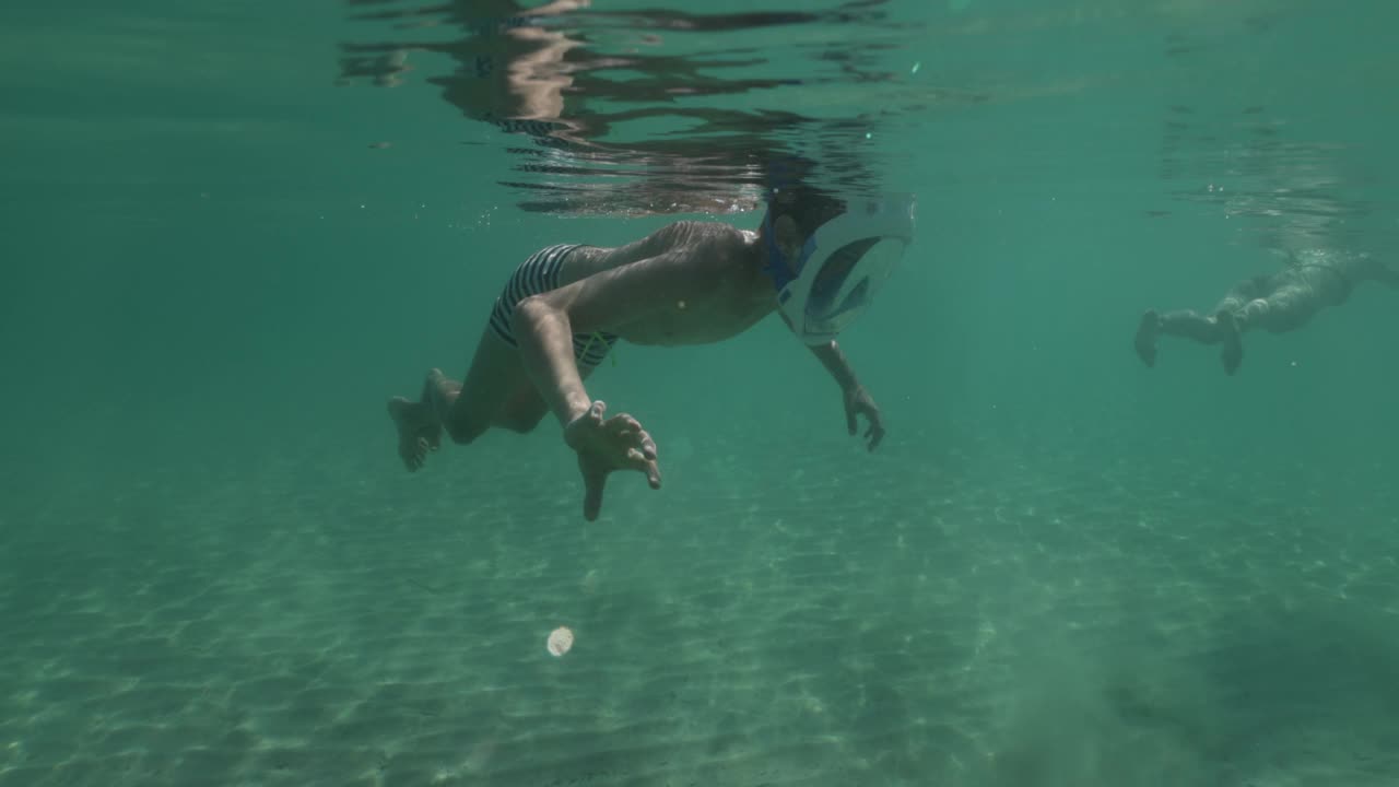 十几岁的男孩喜欢在干净的浅海水下浮潜视频素材