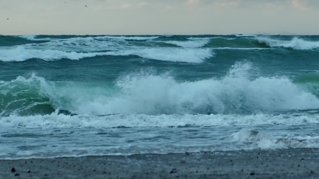 日落时海浪翻滚在海滩上视频素材